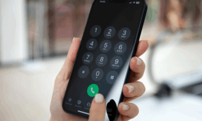 a hand holding a phone with a number on the screen