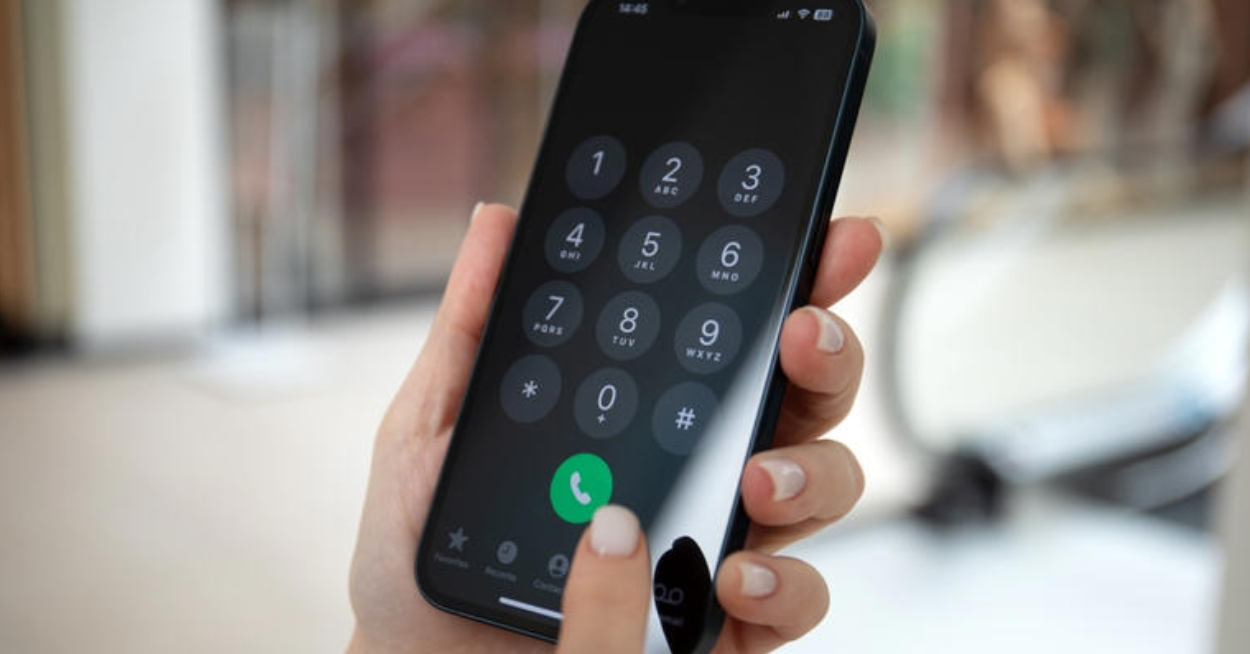 a hand holding a phone with a number on the screen