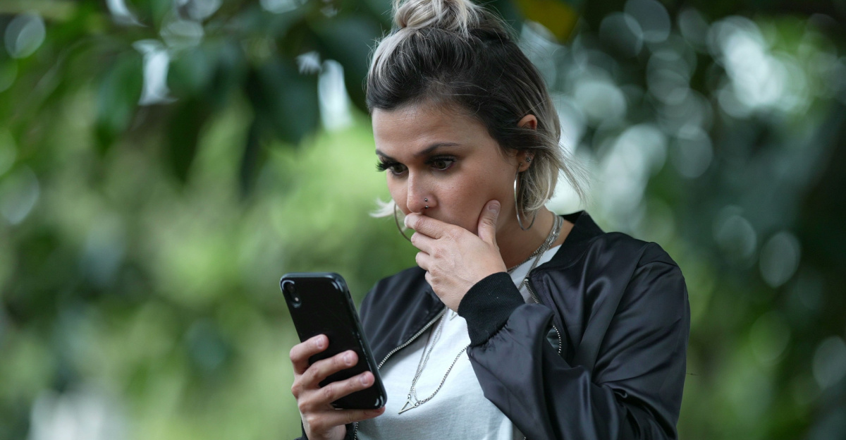 Kvinna förvånad tittar i mobilen