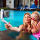 Mamma och dotter tar selfie i poolen