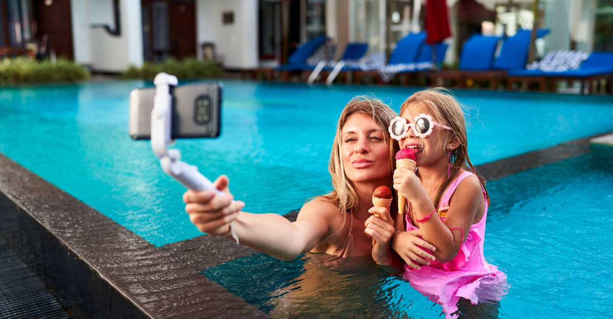 Mamma och dotter tar selfie i poolen