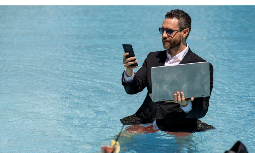 Man i poolen med laptop